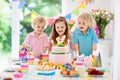 Kids birthday party. Children blow cake candles. Royalty Free Stock Photo