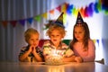 Kids birthday party. Children blow cake candles Royalty Free Stock Photo