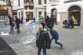Kids blow on giant soap bubbles on Marktplatz in Bad Kissingen, Germany