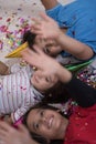 Kids blowing confetti while lying on the floor Royalty Free Stock Photo