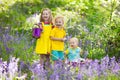 Kids in bluebell flower forest in summer