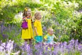 Kids in bluebell flower forest in summer