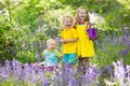 Kids in bluebell flower forest in summer