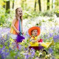 Kids with bluebell flowers, garden tools Royalty Free Stock Photo