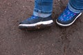 Kids boots in muddy puddle. Colorful winter outdoor rain shoes on childrens feet in action. A child on stay in the mud Royalty Free Stock Photo