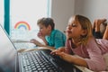 Kids bored staying home, boy and girl with computer indoors Royalty Free Stock Photo