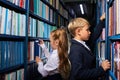 kids boy and girl choose books in library for school Royalty Free Stock Photo