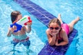 Kids boy and girl playing in the swimming pool. Childhood, summer and vacation concept Royalty Free Stock Photo