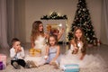 Boy and girls open Christmas presents new year Christmas tree Royalty Free Stock Photo