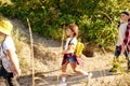 Kids, boys and girls walking on path in forest, field, going hiking together on warm summer day Royalty Free Stock Photo