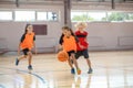 Kids in bright sportswear playing basketball and running after the ball Royalty Free Stock Photo