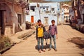 Kids carry a heavy bag on a dusty indian street