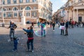 Kids catching and blowing soap bubbles flying on Piazza del Popolo, People Square in Rome full of people, tourists and locals with Royalty Free Stock Photo