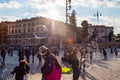 Kids catching and blowing soap bubbles flying on Piazza del Popolo, People Square in Rome full of people, tourists and locals with Royalty Free Stock Photo