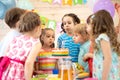 Kids celebrating birthday party and blowing candles on cake Royalty Free Stock Photo