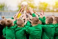 Kids Celebrating Soccer Victory. Young Football Players Holding Trophy Royalty Free Stock Photo