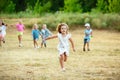 Kids, children running on meadow in summer`s sunlight
