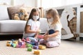 Kids children wearing mask for protect Covid-19, playing block toys in playroom.