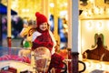 Kids at Christmas fair. Child at traditional street Xmas market in Germany. Winter outdoor fun. Little girl in knitted hat riding