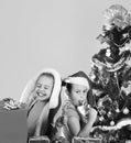 Kids in Christmas hats with gift boxes open presents. Royalty Free Stock Photo