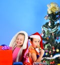 Kids in Christmas hats with gift boxes open presents. Royalty Free Stock Photo