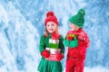 Kids with Christmas presents in winter park in snow Royalty Free Stock Photo