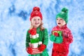 Kids with Christmas presents in winter park in snow Royalty Free Stock Photo