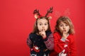 Kids in Christmas sweaters and festive headbands on red background, space for text Royalty Free Stock Photo