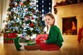 Kids at Christmas tree. Children open presents Royalty Free Stock Photo