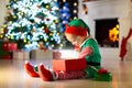 Kids at Christmas tree. Children open presents Royalty Free Stock Photo