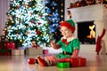 Kids at Christmas tree. Children open presents Royalty Free Stock Photo