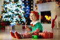 Kids at Christmas tree. Children open presents Royalty Free Stock Photo