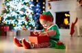 Kids at Christmas tree. Children open presents Royalty Free Stock Photo