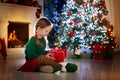 Kids at Christmas tree. Children open presents Royalty Free Stock Photo