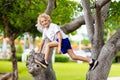 Kids climb tree in summer park. Child climbing Royalty Free Stock Photo