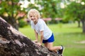 Kids climb tree in summer park. Child climbing
