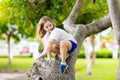 Kids Climb Tree In Summer Park. Child Climbing