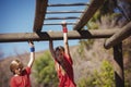 Kids climbing monkey bars during obstacle course training Royalty Free Stock Photo