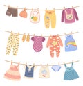 Kids clothes on ropes with clothespin. Cute child dress, shirts, pants. Children clothing hanging on rope, drying baby