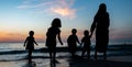 Kids collecting sea shells during sunset at beach