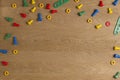 Kids construction toys tools border. Colorful screws and nuts on wooden background. Top view. Flat lay