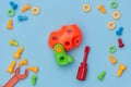 Kids construction toys tools: colorful screwdrivers, screws and nuts on blue background. Top view. Flat lay. Copy space for text Royalty Free Stock Photo