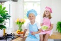 Kids cook in white kitchen. Children cooking Royalty Free Stock Photo