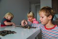 Kids count money, boy and girls put coins into piggy bank