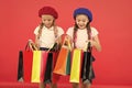 Kids cute schoolgirls hold bunch shopping bags. Children satisfied by shopping red background. Obsessed with shopping