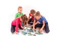 Kids of different age solving jigsaw puzzle together Royalty Free Stock Photo