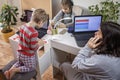 Kids doing homework and mother working online in one room, distant education at home Royalty Free Stock Photo