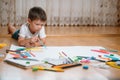 Kids drawing on floor on paper. Preschool boy and girl play on floor with educational toys - blocks, train, railroad, plane. Toys