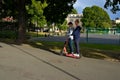 Two teenagers on an electric kick bike.