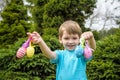 Kids on Easter egg hunt in blooming spring garden. Children searching for colorful eggs in flower meadow. Toddler boy and his brot Royalty Free Stock Photo